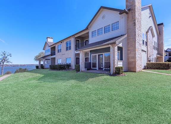 A large house with a well-manicured lawn in front.
