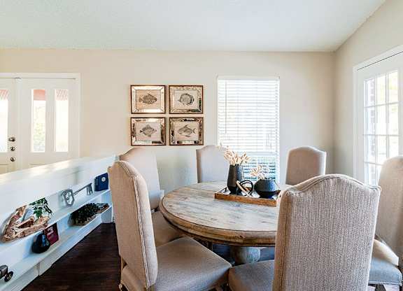 A dining room with a table and chairs.