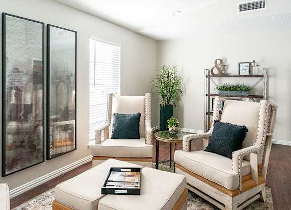 A living room with a white couch, a chair, and a coffee table.