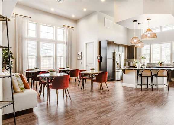 A modern kitchen and dining room with wooden floors and furniture.