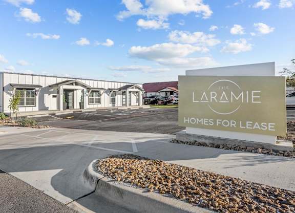 the laramie homes for lease sign in front of the building