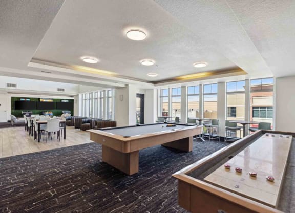 a community room with a pool table and a dining area