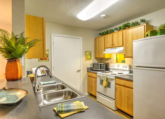 A kitchen with a white refrigerator, stove, and oven.