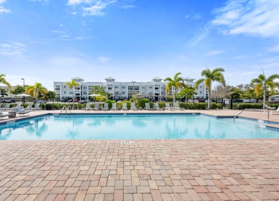 a resort-style swimming pool with artments in the background