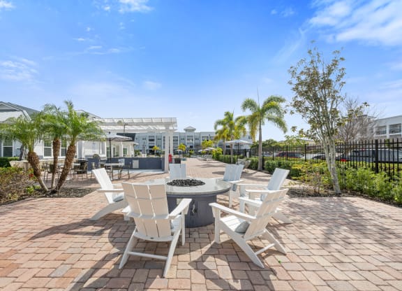 a communalm outdoor area with white chairs and a fire pit