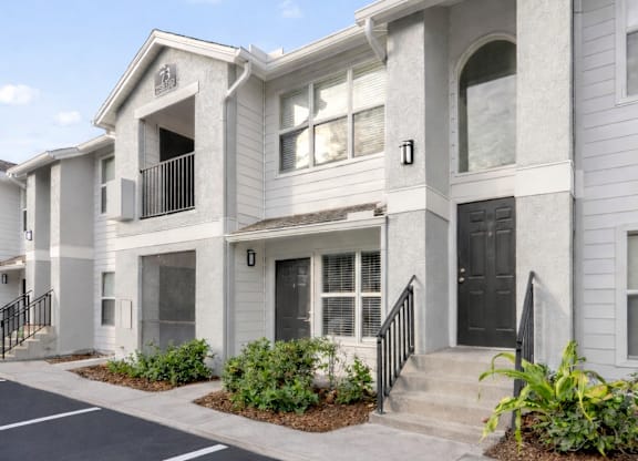 A row of townhouses with a parking lot in front.