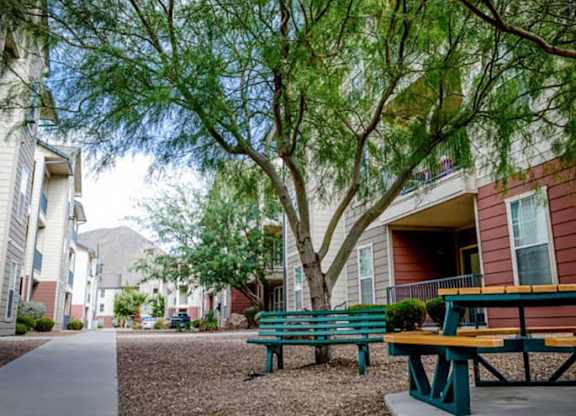 a picnic table and benches in front of a building