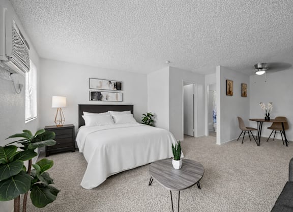 A bedroom with a large bed and a small table.