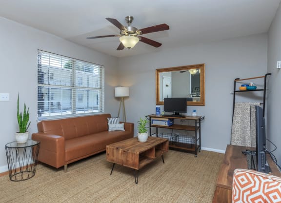 a living room with a ceiling fan and a large window