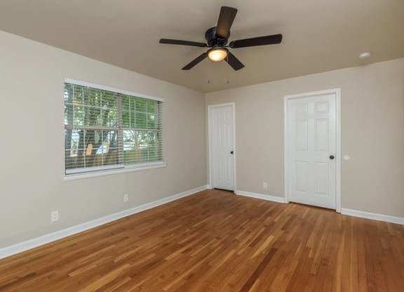an empty room with a ceiling fan and a window