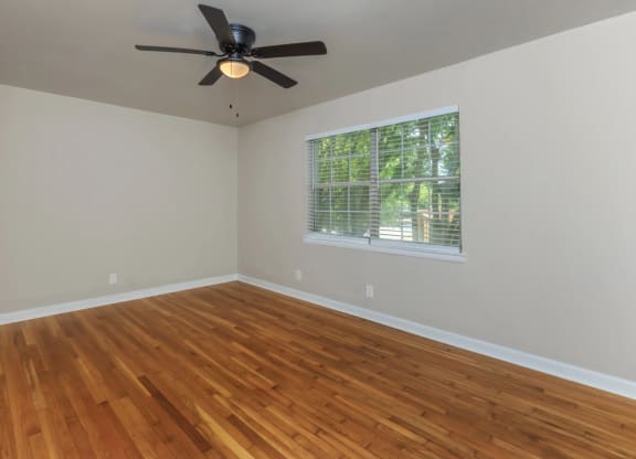 an empty room with a ceiling fan and a window
