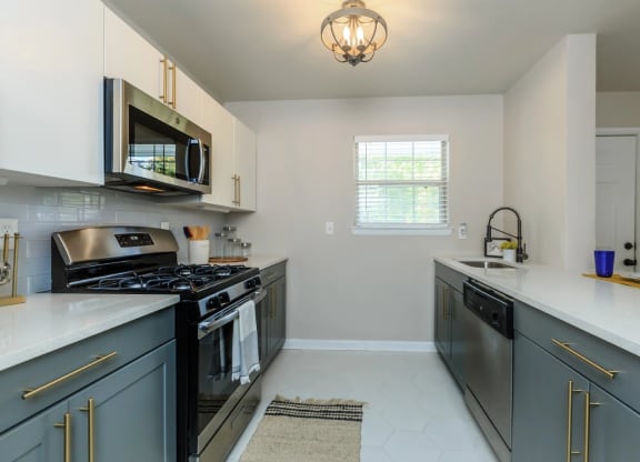 a kitchen with gray cabinets and white countertops