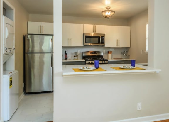 a kitchen with white cabinets and stainless steel appliances