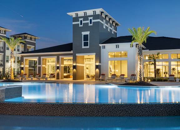 A modern house with a pool in front.