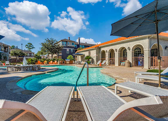 A swimming pool with a slide and sun loungers.