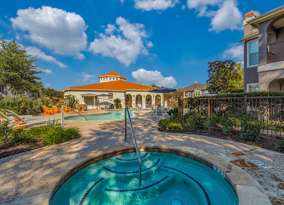 A swimming pool with a fountain in the middle of it.