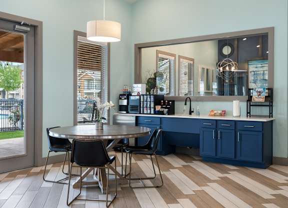A kitchen with a table and chairs in front of a window.