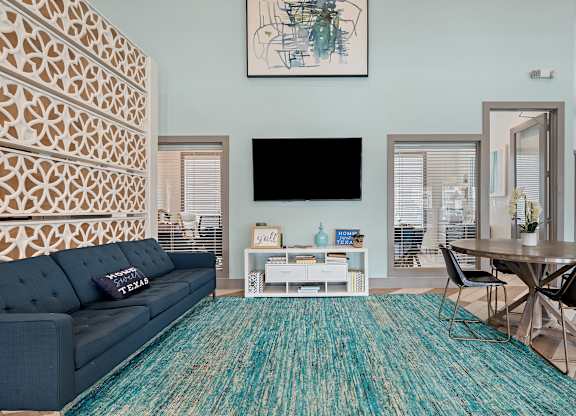 A living room with a blue couch and a patterned wall.