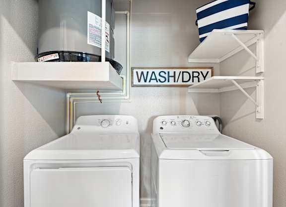 Two white washing machines in a laundry room.