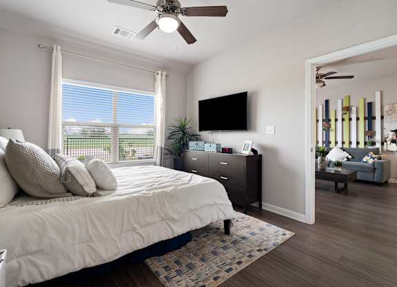 A bedroom with a large bed and a flat screen TV mounted on the wall.
