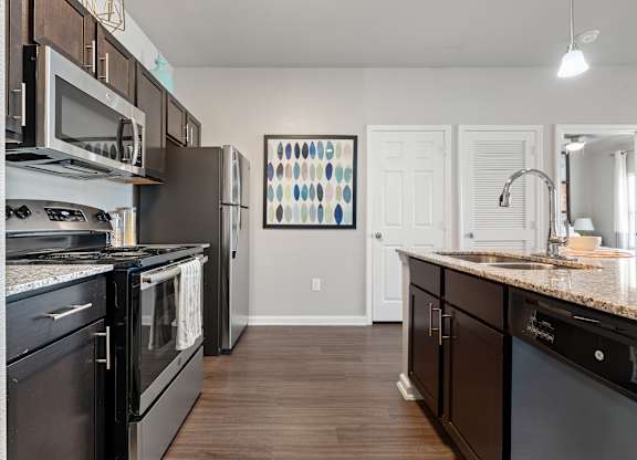 A kitchen with black appliances and wooden cabinets.