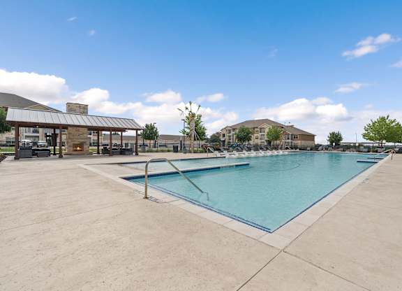 A large outdoor swimming pool with a building in the background.