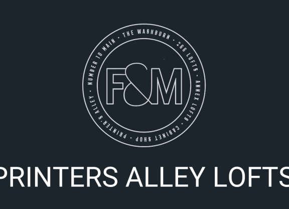 a logo with the words printers alley lofts on a black background