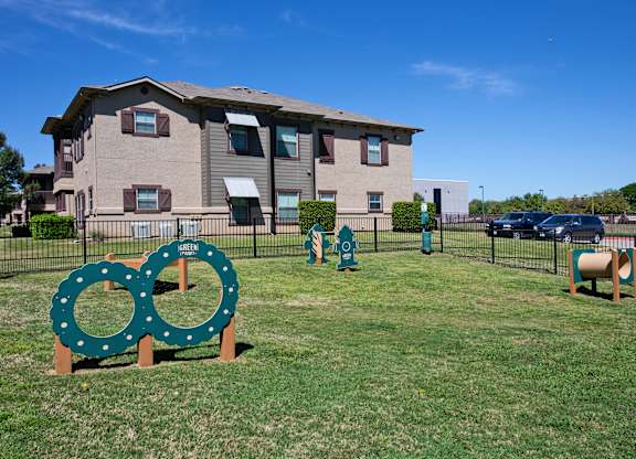 A green sign with two circles on it is in front of a building.