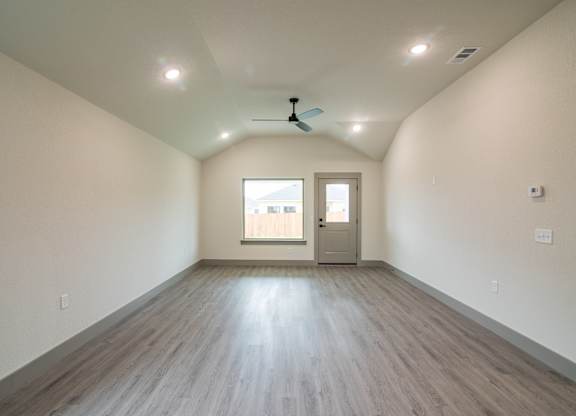 A room with a ceiling fan and a door leading to a balcony.