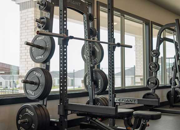 A black weight bench with a barbell on it.