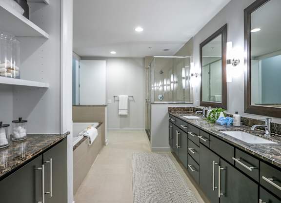 A bathroom with a sink, mirror, and a towel hanging on the wall.