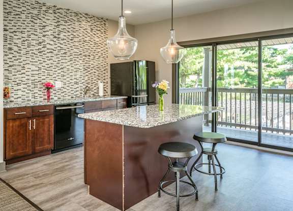 A kitchen with a bar and stools.