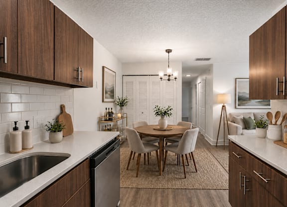 A modern kitchen with wooden cabinets and a dining table.