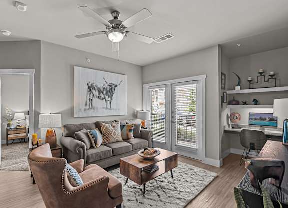 a living room with a couch and a ceiling fan