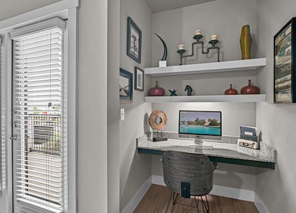 a home office with a computer desk and a window