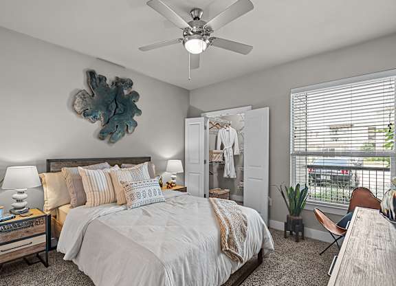 a bedroom with a large bed and a ceiling fan
