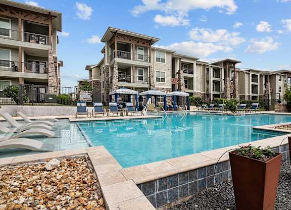 a swimming pool with an apartment building in the background