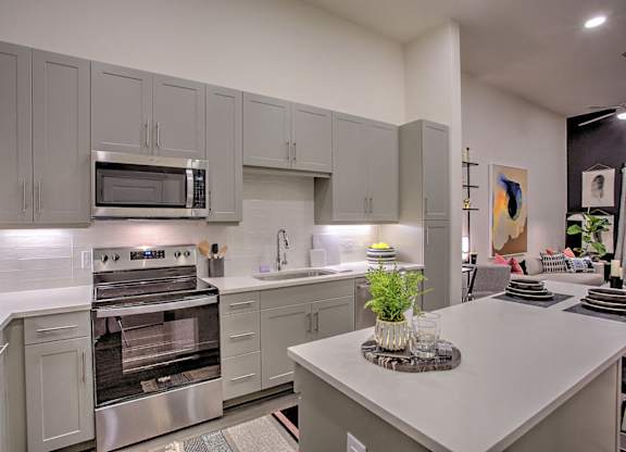 A modern kitchen with a stainless steel refrigerator and oven.