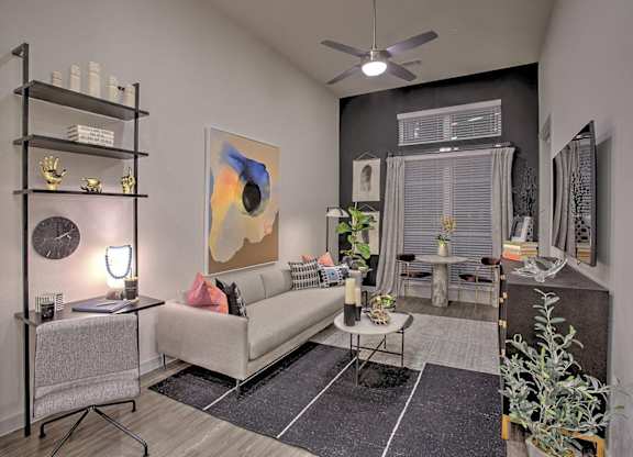 A living room with a white couch, a black shelf, and a painting on the wall.