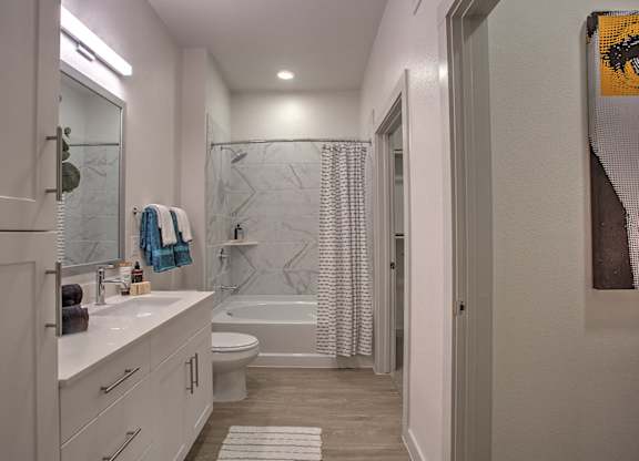 A bathroom with a white counter and a white toilet.