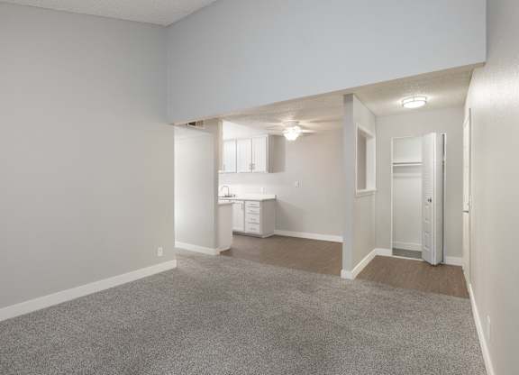 A spacious, empty room with a carpeted floor and white walls.