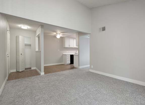 A large, empty room with a carpeted floor and white walls.