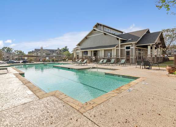 A large swimming pool in front of a house.