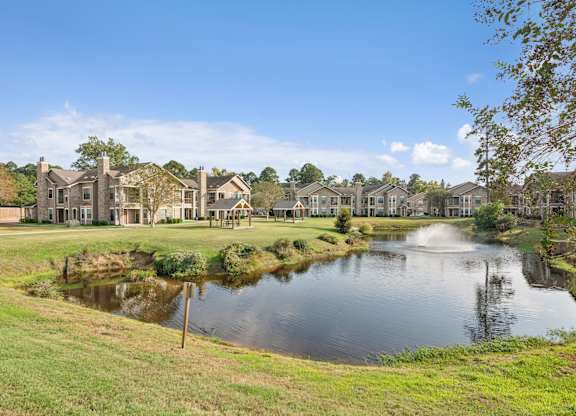 A pond in front of a row of houses.