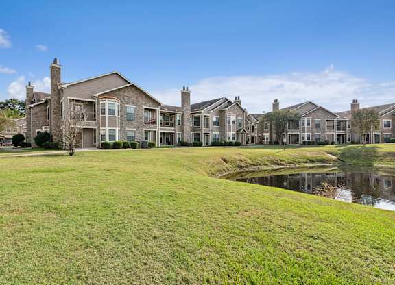 A row of houses with a pond in front.