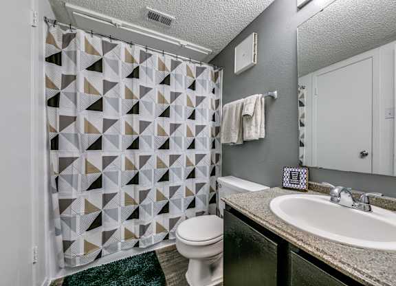 a bathroom with a shower and a sink and a toilet