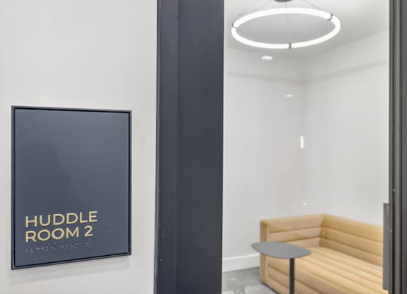 A sign that says Huddle Room 2 is on the wall.