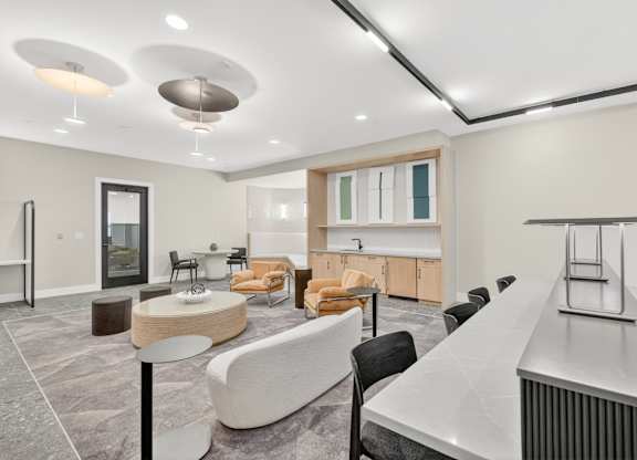 A modern living room with a long white table and a grey sofa.