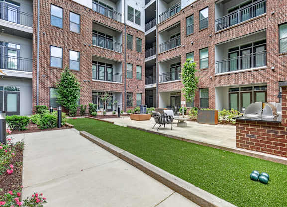A brick building with a green lawn in front.