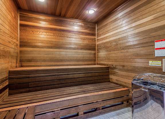 A wooden sauna with benches and a sign on the wall.